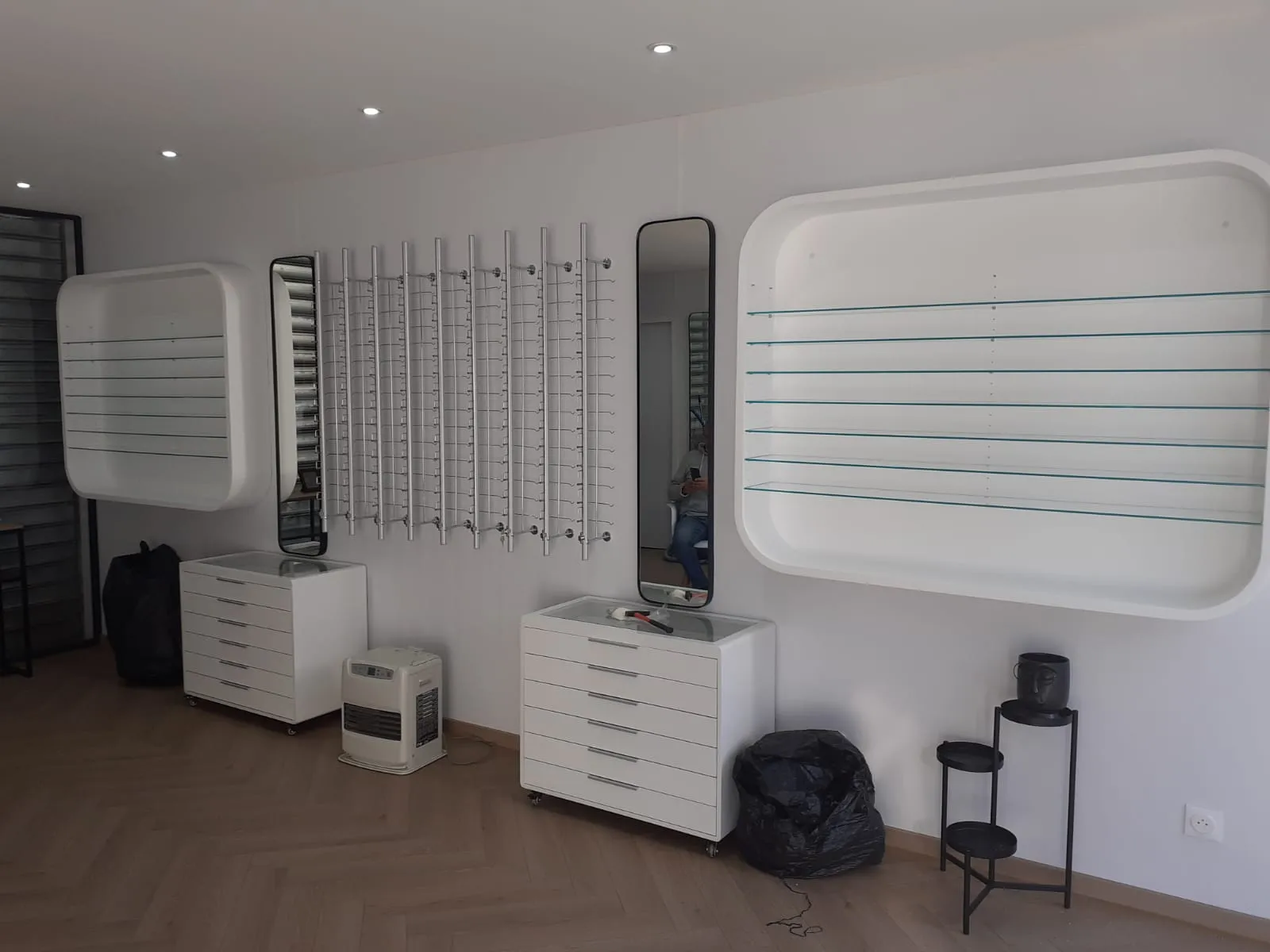 Présentoirs muraux laqués et étagères en verre dans une boutique d'optique