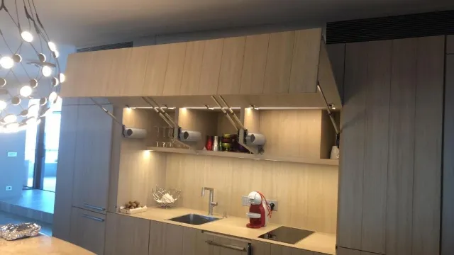 Cuisine linéaire en bois clair, meubles hauts à portes relevables