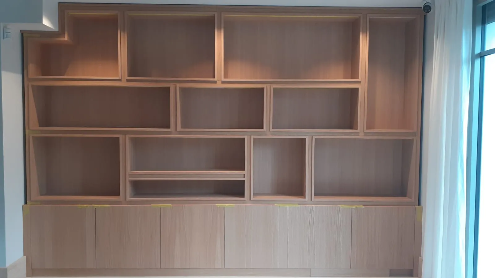 Bibliothèque toute hauteur en cours de montage, façades basses protégées avant finition