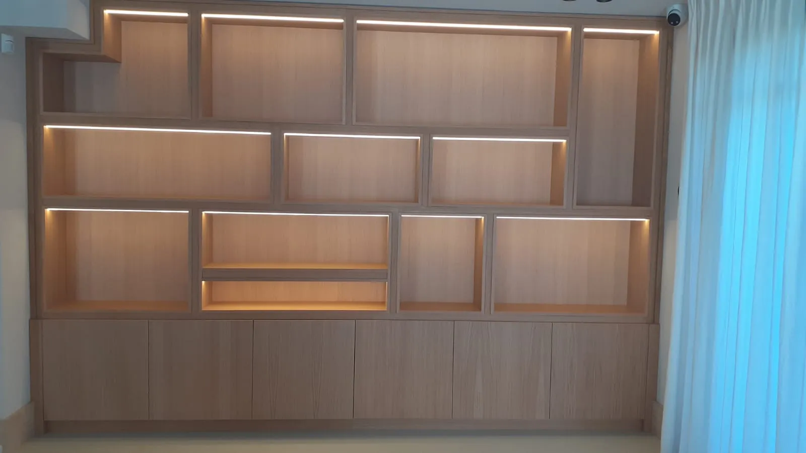 Bibliothèque sur mesure toute hauteur terminée, niches à éclairage LED intégré
