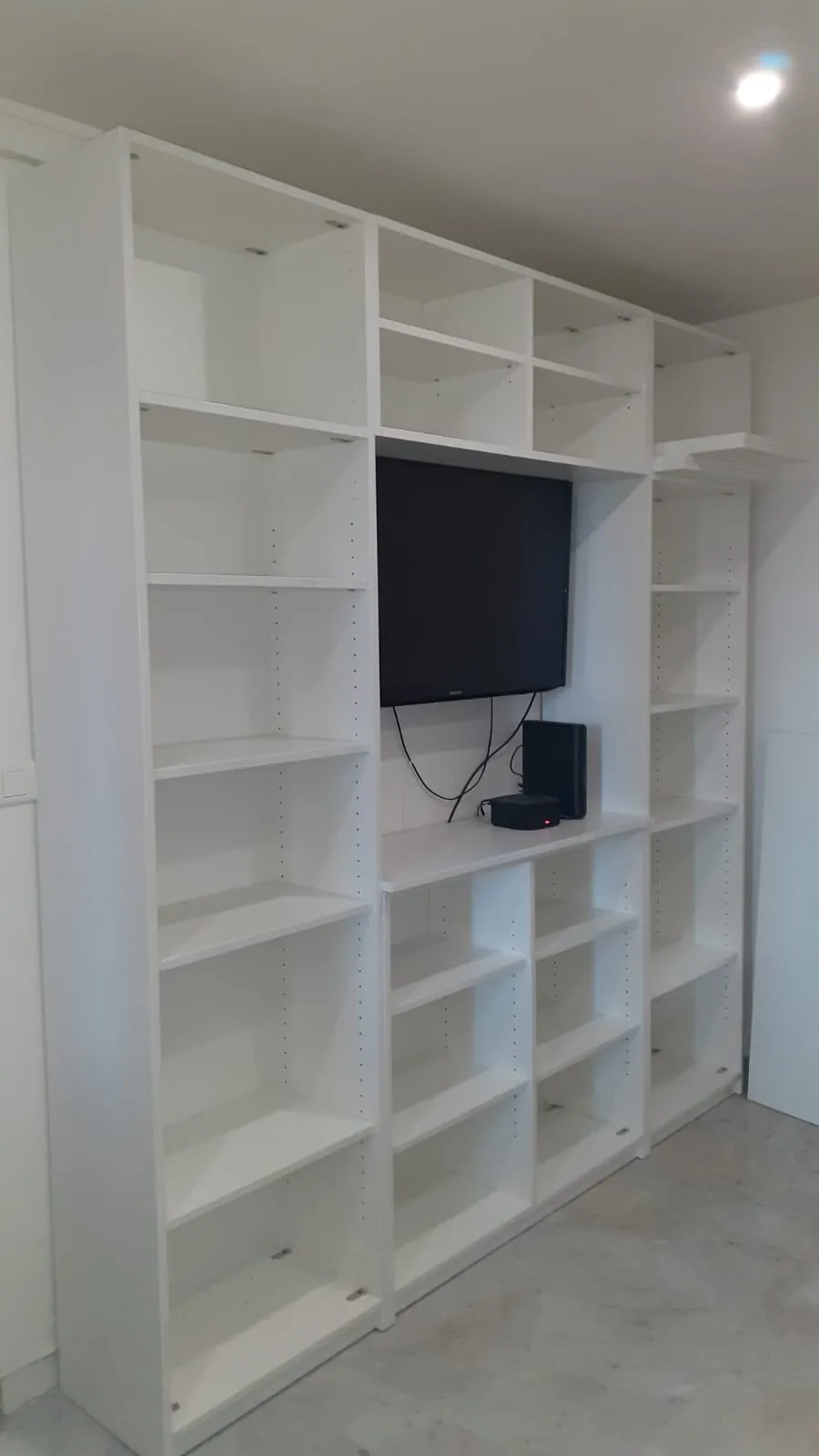 Bibliothèque et meuble TV blancs sur mesure, étagères sur toute la longueur