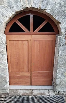 Porte d'entrée en bois cintrée surmontée d'une imposte rayonnante
