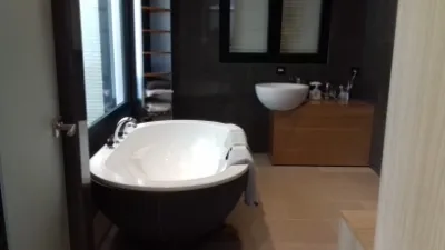 Salle de bain avec baignoire îlot et meuble vasque en bois
