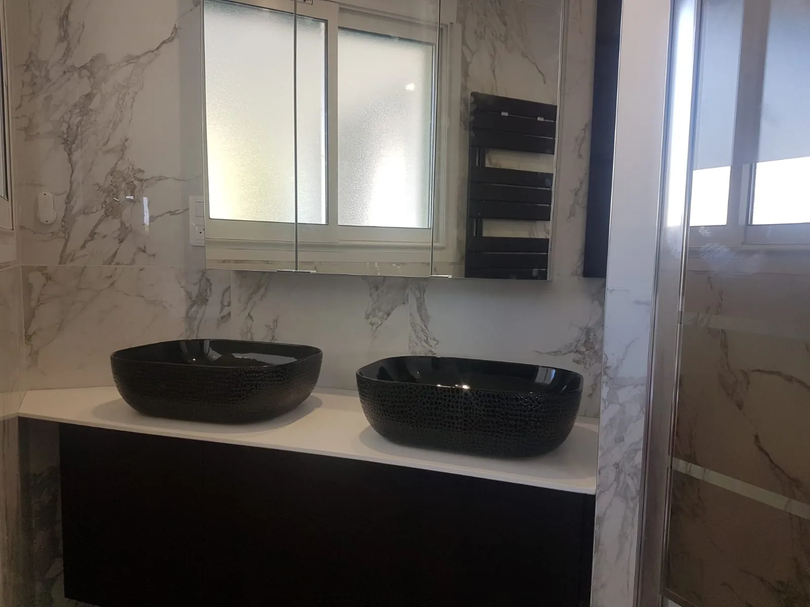 Salle de bain en marbre, double vasque noire sur meuble suspendu