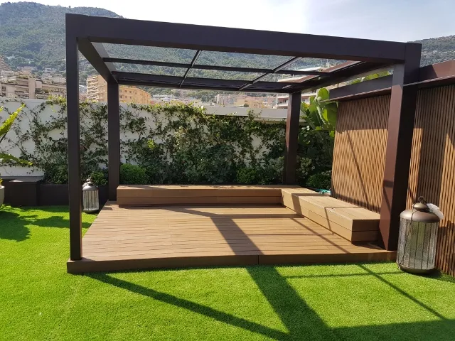 Pergola bioclimatique aluminium sur terrasse bois, avec banquette