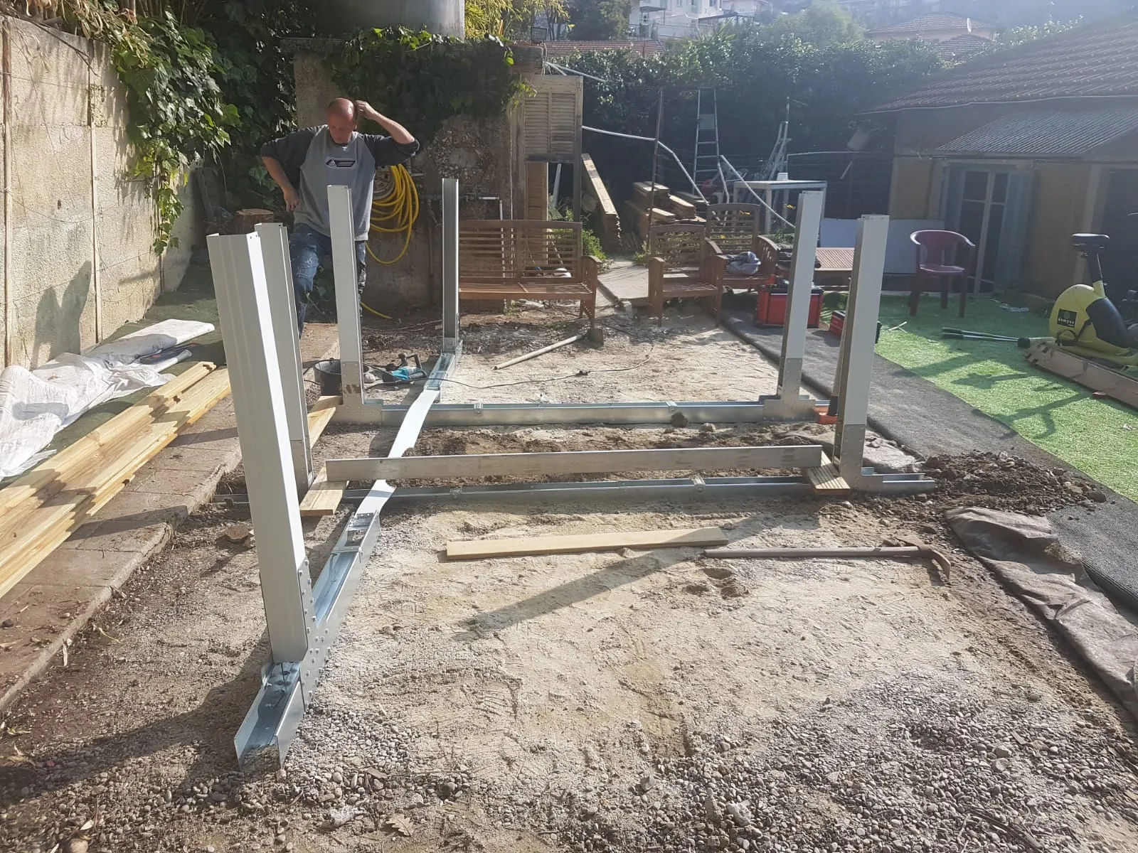 Montage de la structure d'une pergola, poteaux aluminium dans le jardin