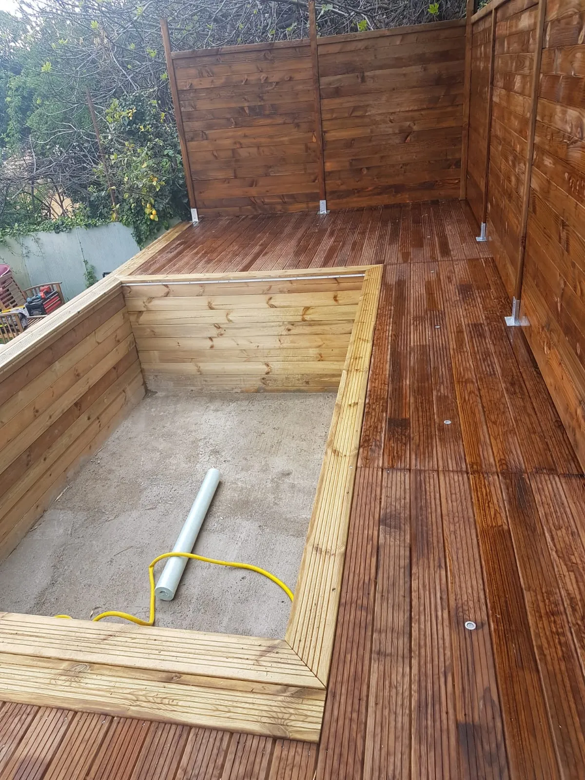 Terrasse bois et claustras autour d'un bassin de piscine en construction
