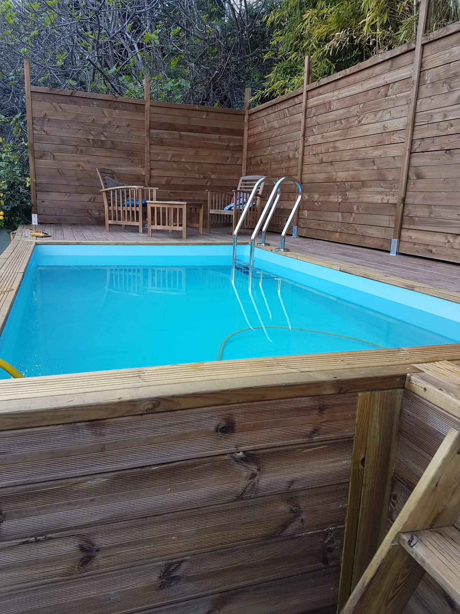 Piscine bois et terrasse abritées par des claustras brise-vue