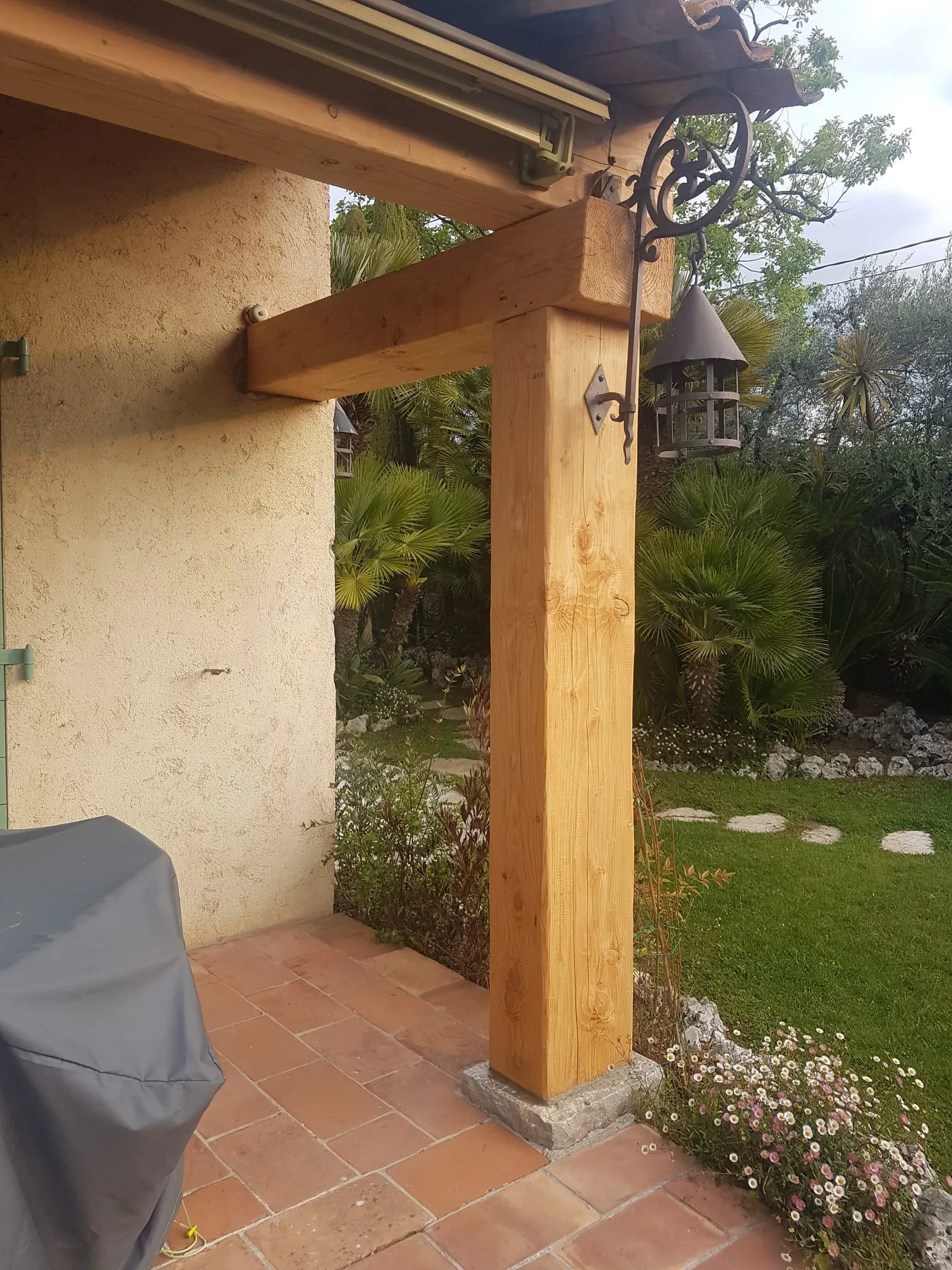 Pergola adossée sur poteaux bois massif, terrasse en tomettes